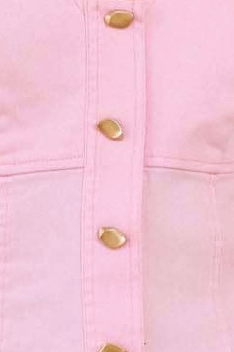 Close-up of a pink denim jacket with gold buttons on a blurred background