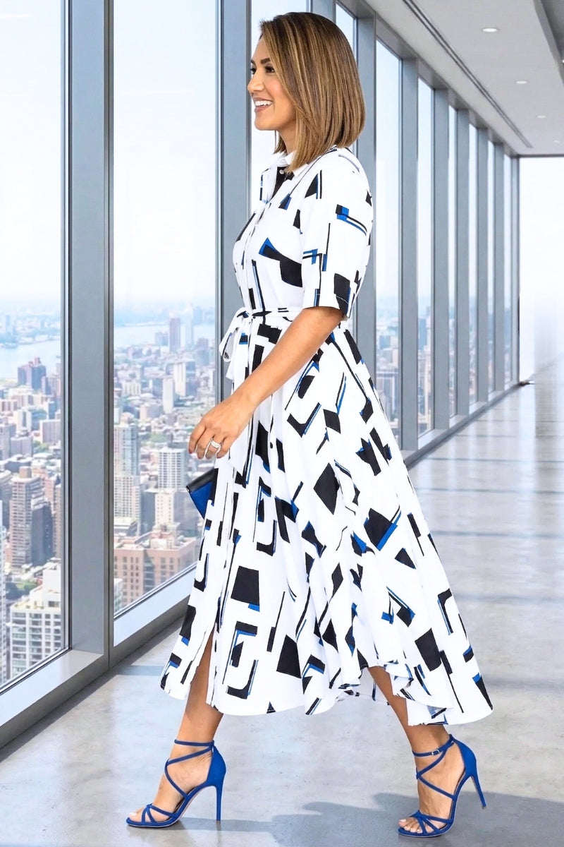 Woman in a geometric patterned dress standing in front of a cityscape view.