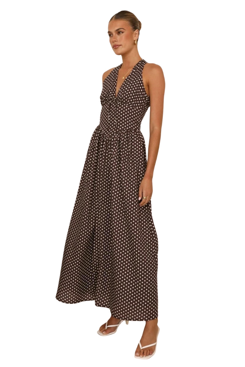 Woman wearing a black and white polka dot dress on a white background