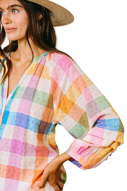Woman wearing a colorful checkered dress with a white background