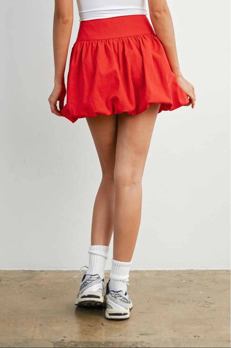 Woman wearing a red skirt with a white background