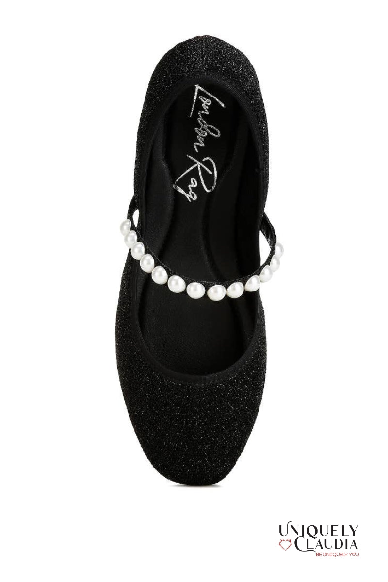 Black glittery ballerina shoe with pearl strap on a white background