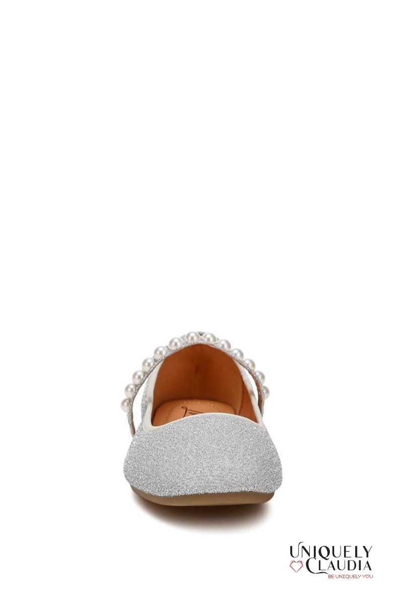 Silver glittery flat shoe with pearl embellishments on a white background