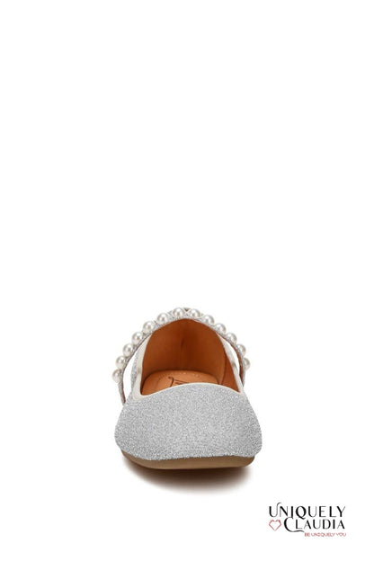 Silver glittery flat shoe with pearl embellishments on a white background
