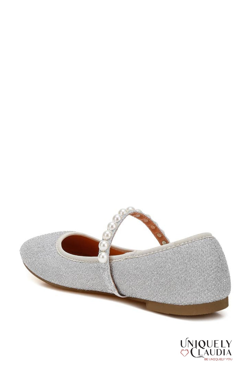Silver glittery ballerina shoe with a strap and pearl detail on a white background
