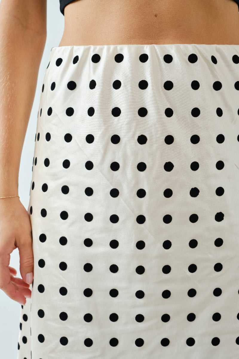 White skirt with black polka dots worn by a person