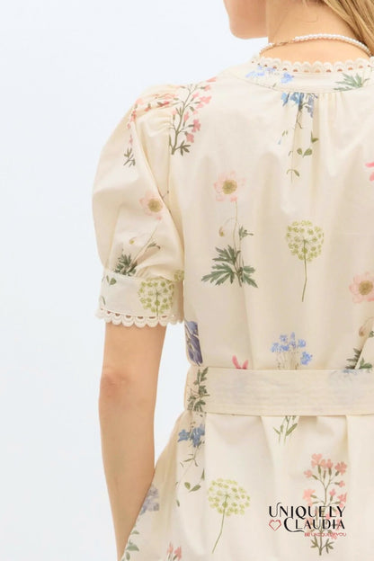 Floral-patterned dress with 'Uniquely Claudia' branding on a light background