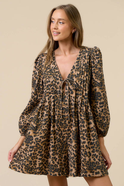 Woman wearing a leopard print romper against a beige background