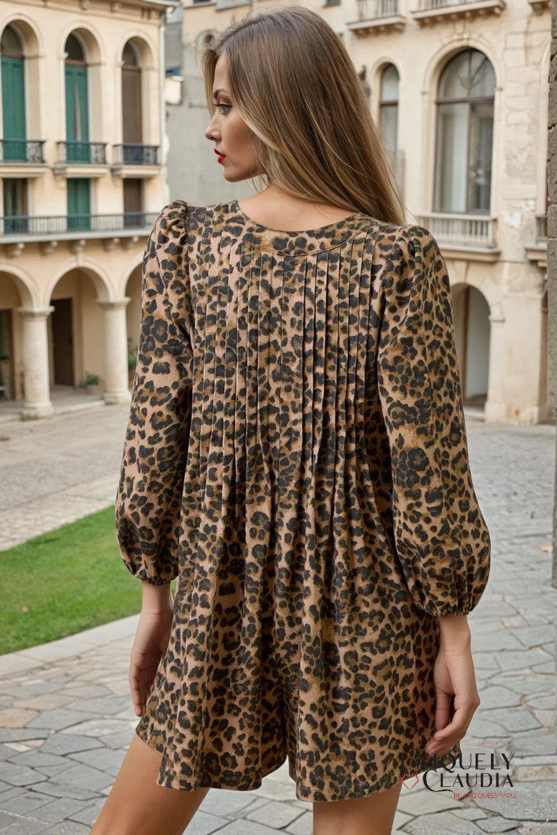 Woman wearing a leopard print romper in an outdoor setting with classical architecture.