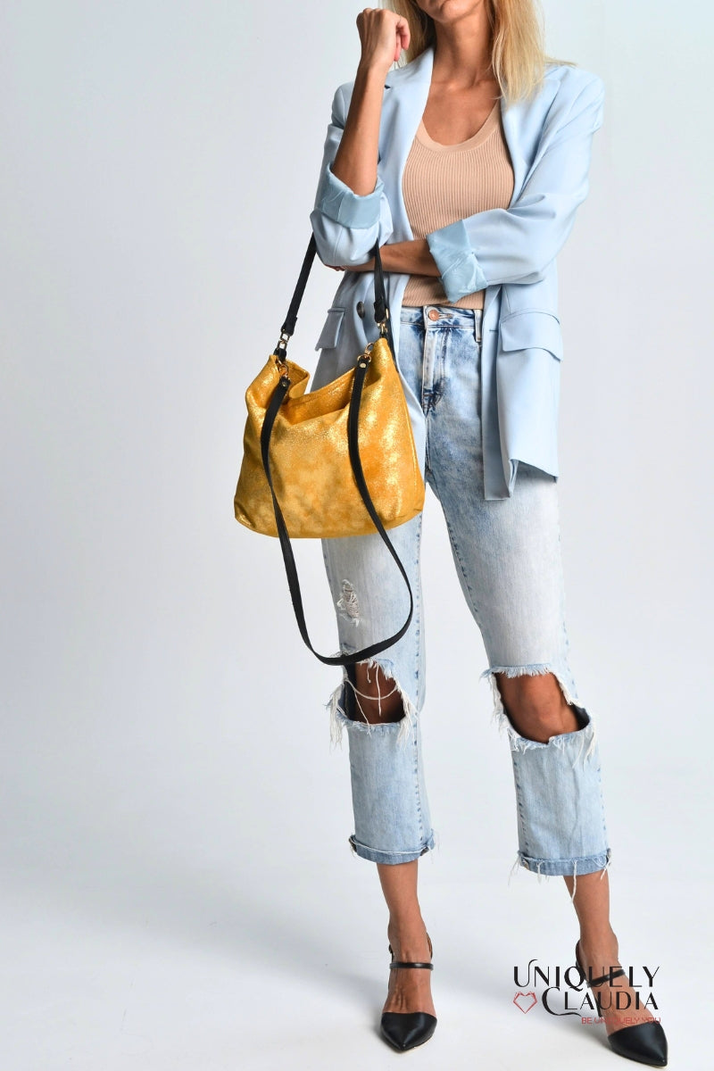 Woman holding a gold handbag against a white background
