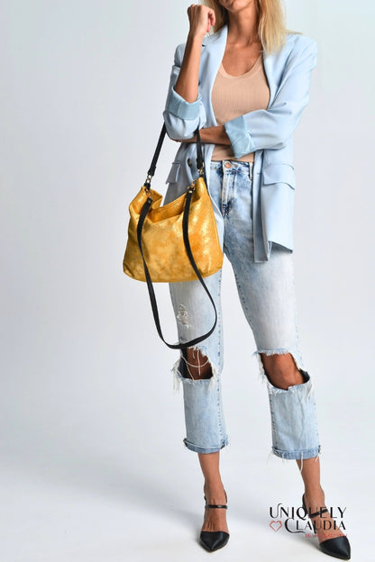 Woman holding a gold handbag against a white background
