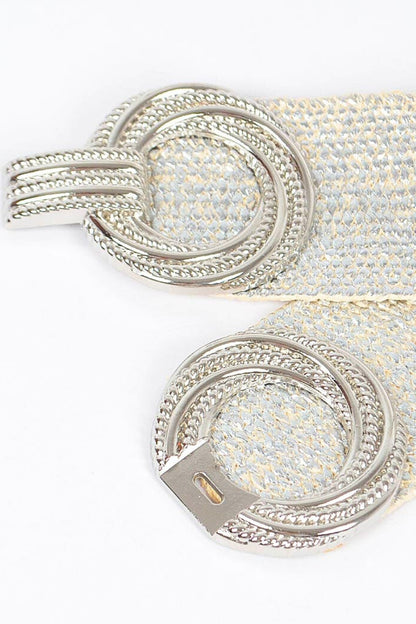 Close-up of a silver belt buckle with intricate design on a white background