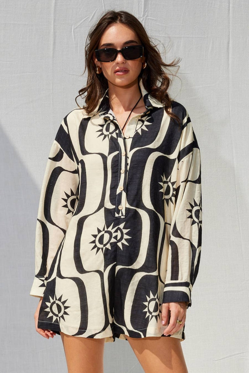 Woman wearing a black and white patterned dress against a gray background