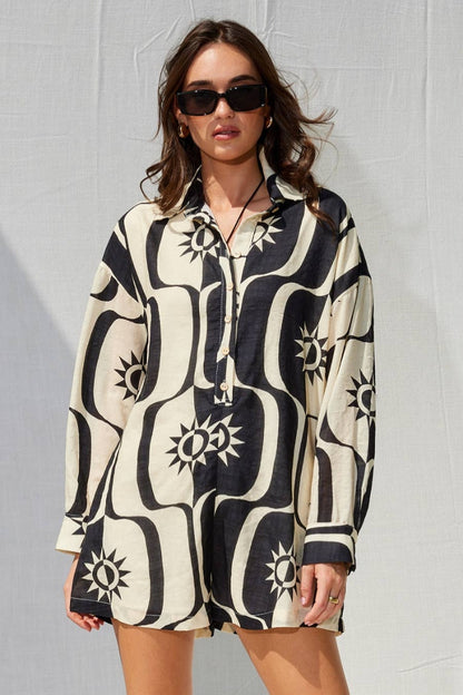Woman wearing a black and white patterned dress against a gray background