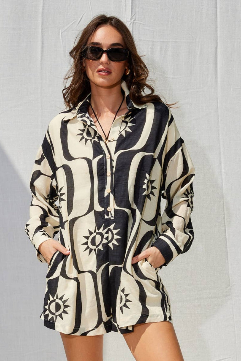 Woman wearing a patterned shirt dress against a plain background