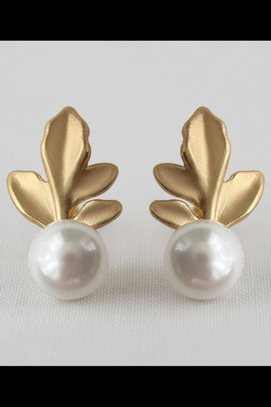 Gold leaf earrings with pearl centers on a light gray background