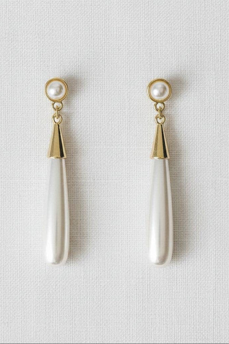 Pair of pearl drop earrings with gold tops on a light gray background