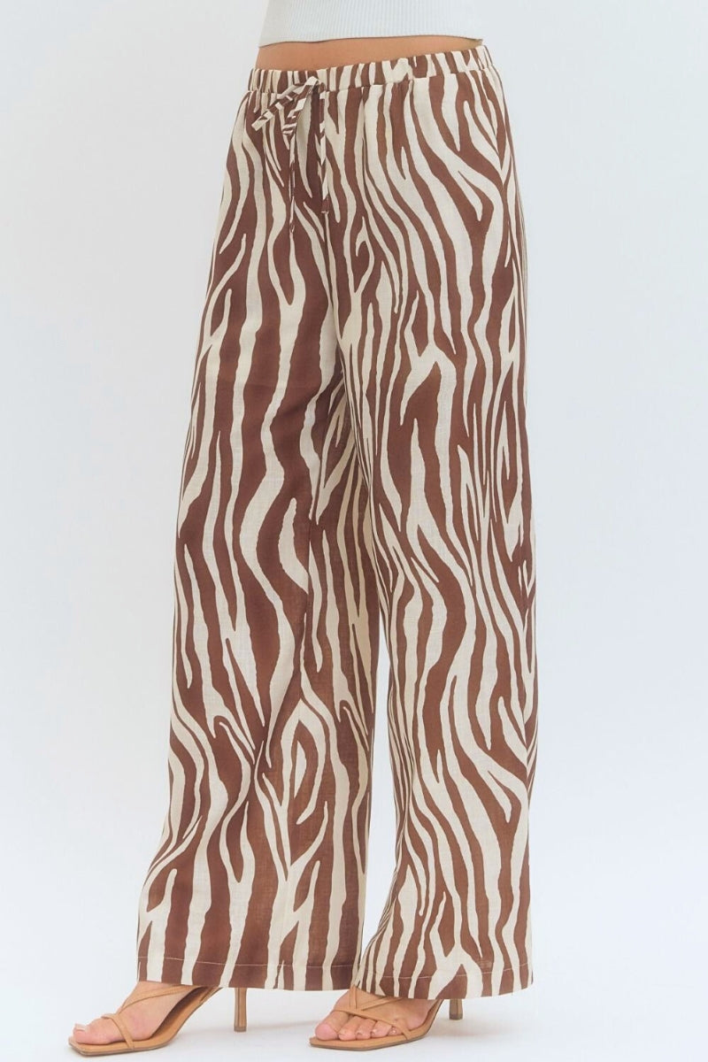Zebra print pants worn by a person on a white background