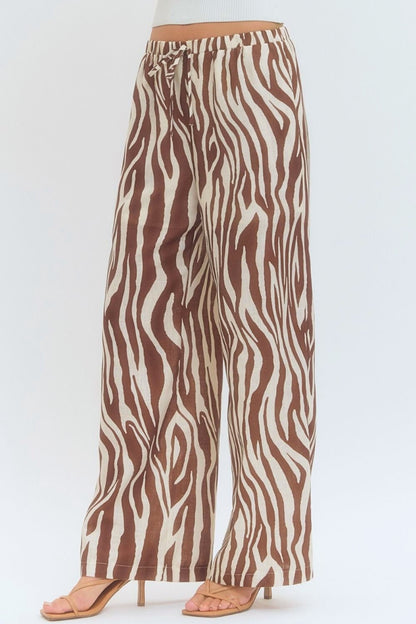 Zebra print pants worn by a person on a white background