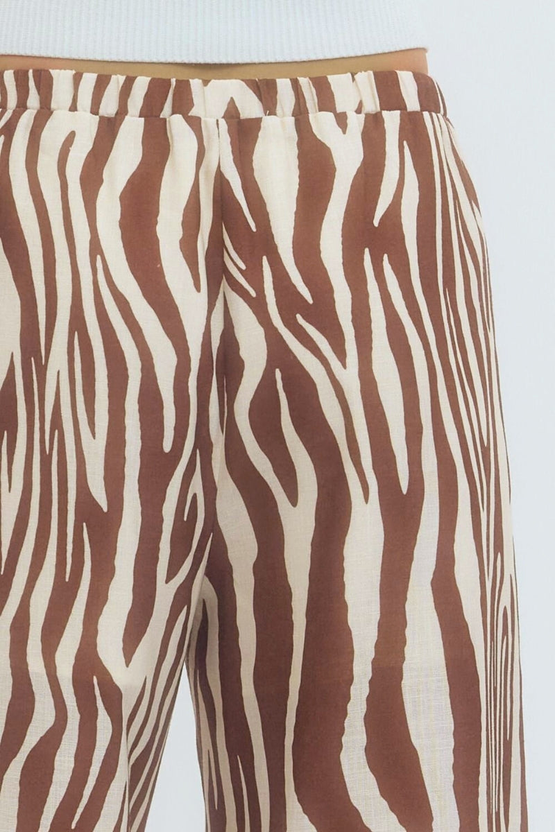 Brown and white zebra-striped pants on a light blue background