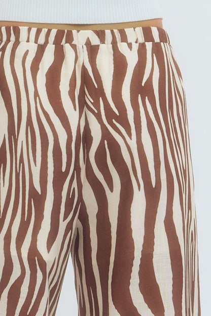 Brown and white zebra-striped pants on a light blue background