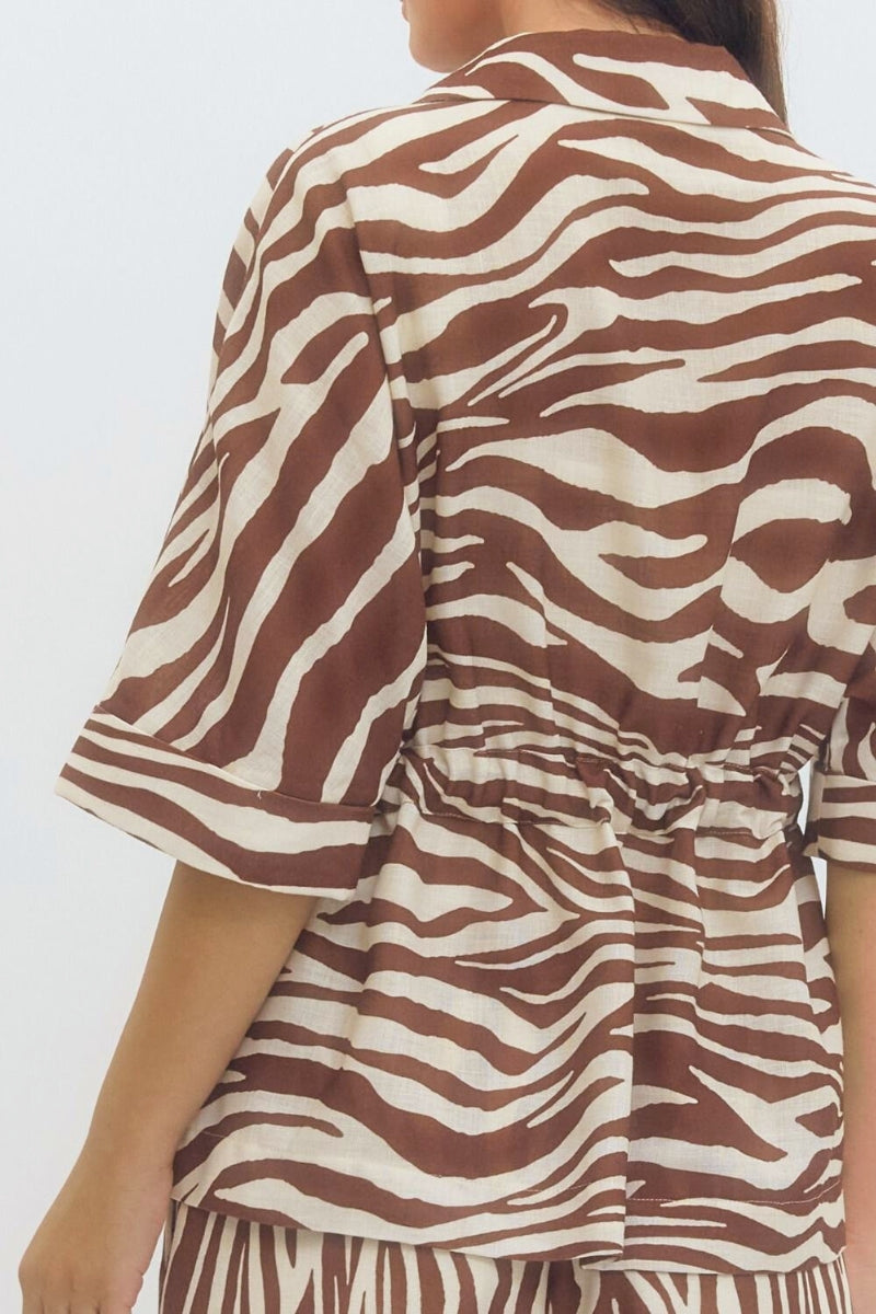 Person wearing a brown and white zebra patterned outfit on a plain background