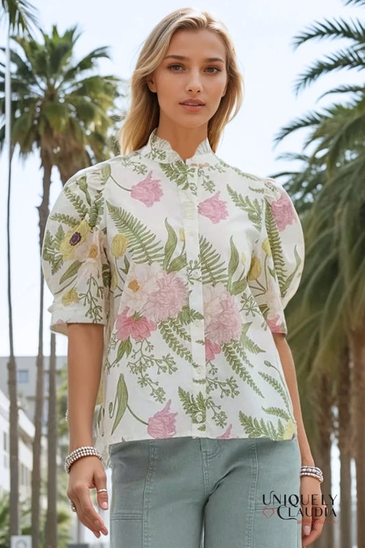 Woman wearing a floral blouse with palm trees in the background