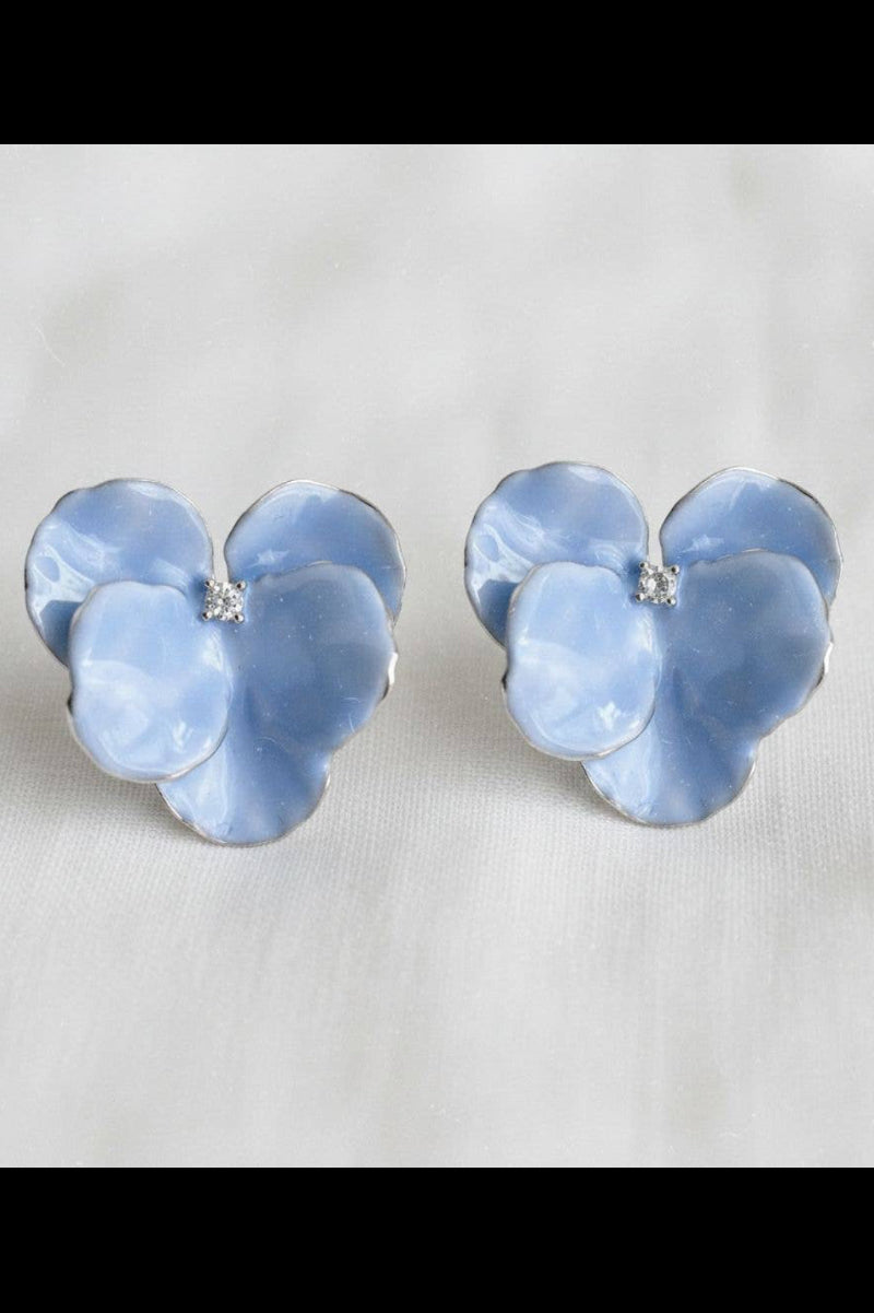 Pair of blue flower-shaped earrings on a light gray background