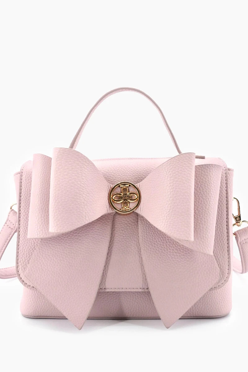 Pink handbag with a large bow on a white background