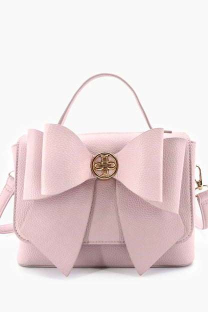 Pink handbag with a large bow on a white background