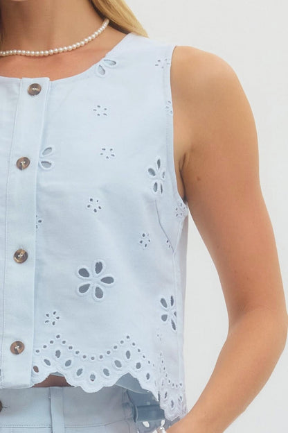 Light blue sleeveless top with floral cut-out details on a white background
