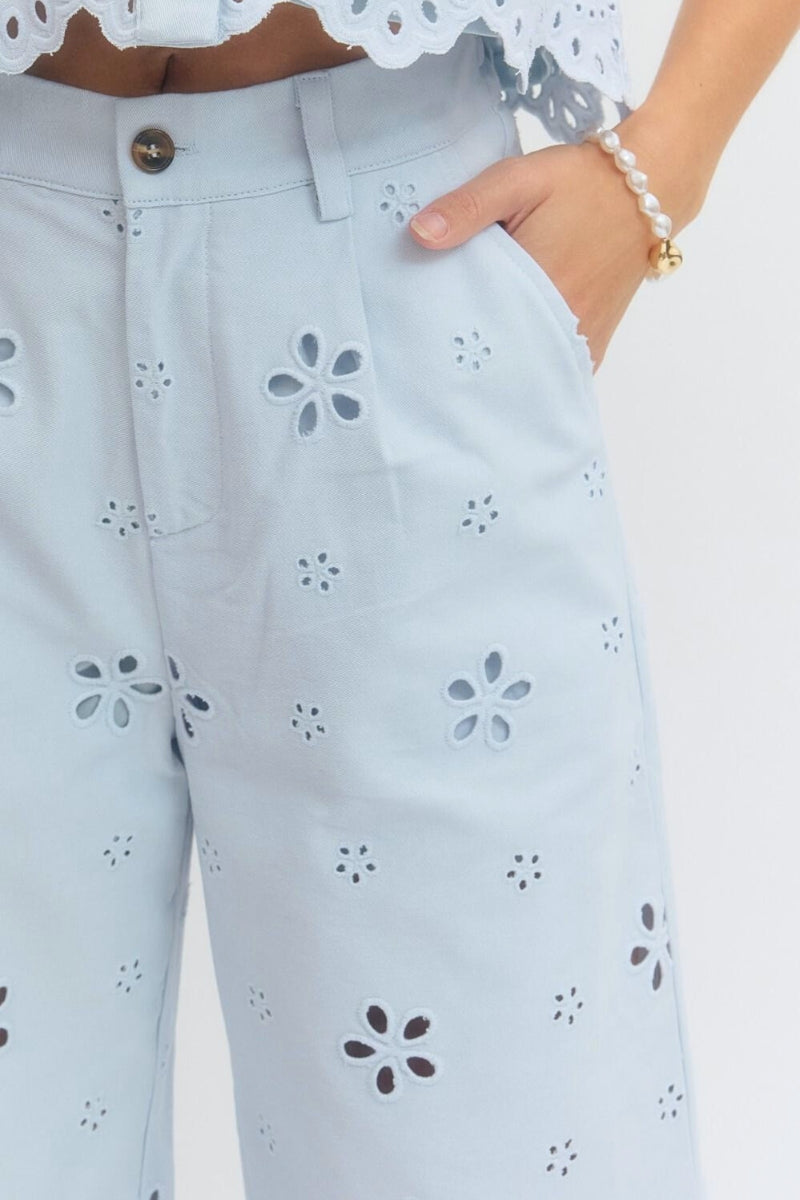 Light blue jeans with floral cut-out pattern on a white background