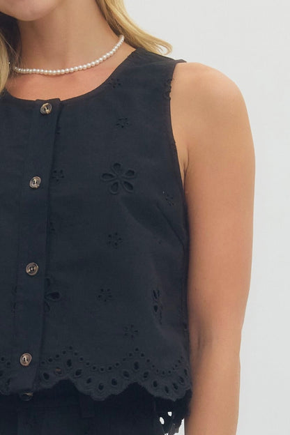 Navy sleeveless top with floral cut-out details on a plain background