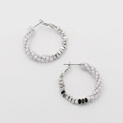 Silver hoop earrings with beaded design on a light gray background