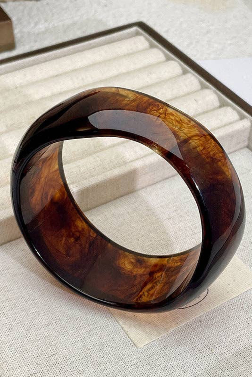 Tortoiseshell bangle on a textured surface