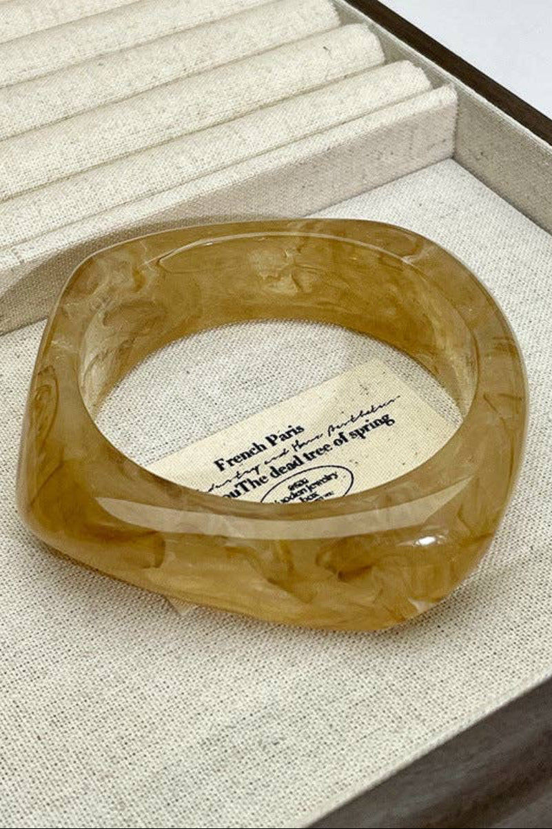 Brown ring on a textured surface with a card underneath