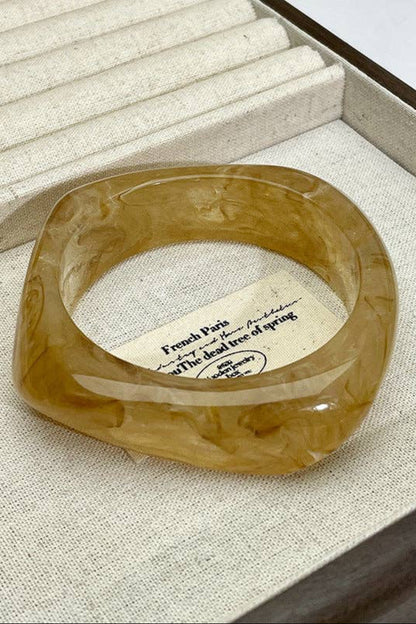 Brown ring on a textured surface with a card underneath