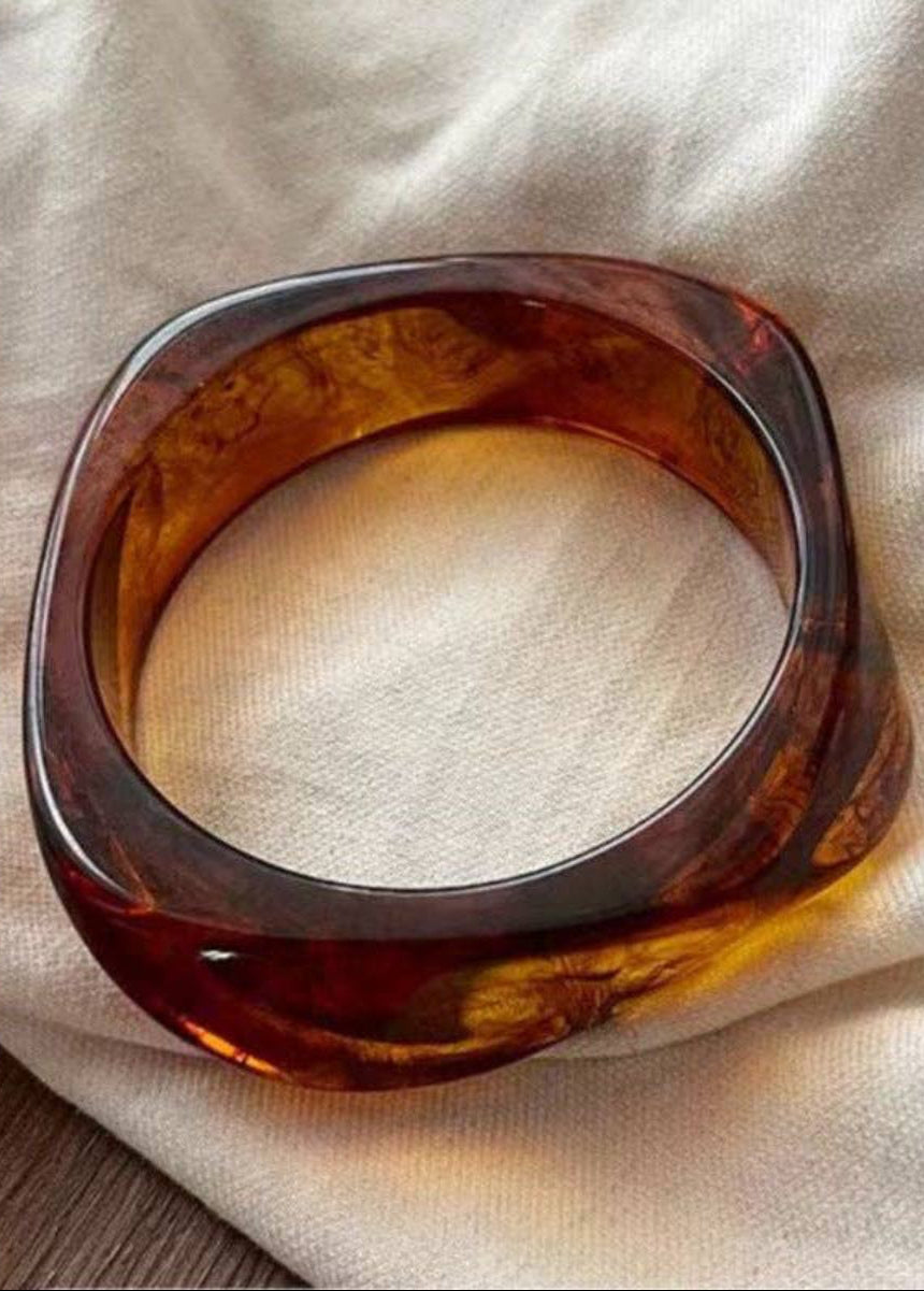 Brown tortoiseshell bracelet on a beige fabric background