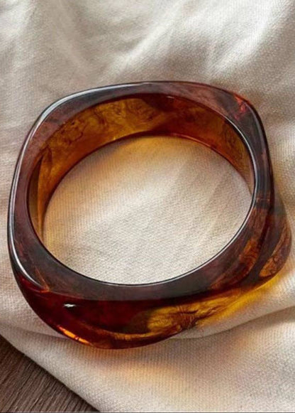Brown tortoiseshell bracelet on a beige fabric background