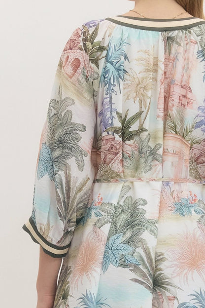 Multicolored floral and palm tree patterned shirt on a plain background