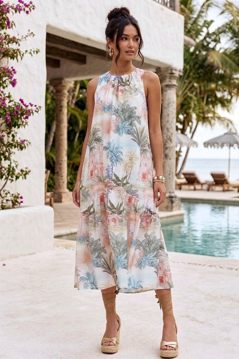 Woman in a floral dress standing by a poolside with palm trees in the background