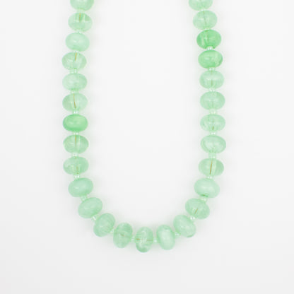 Green beaded necklace on a white background