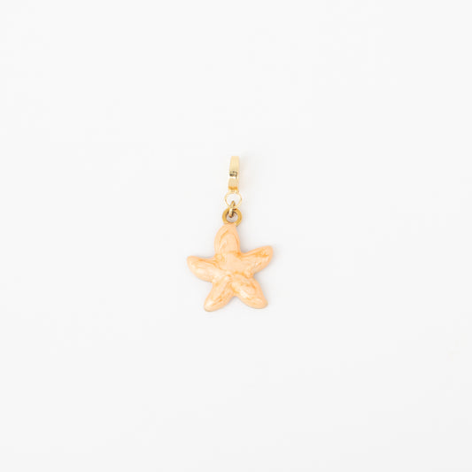 Gold starfish charm on a white background
