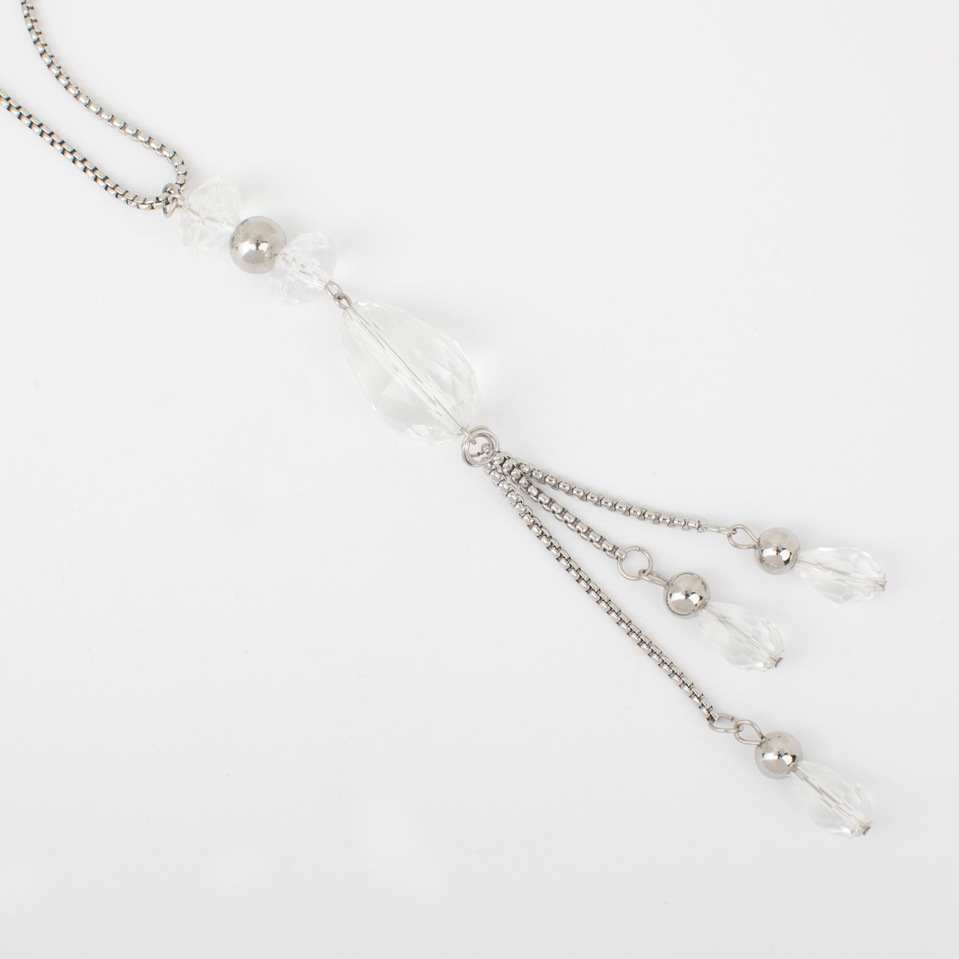 Silver necklace with beads on a light gray background