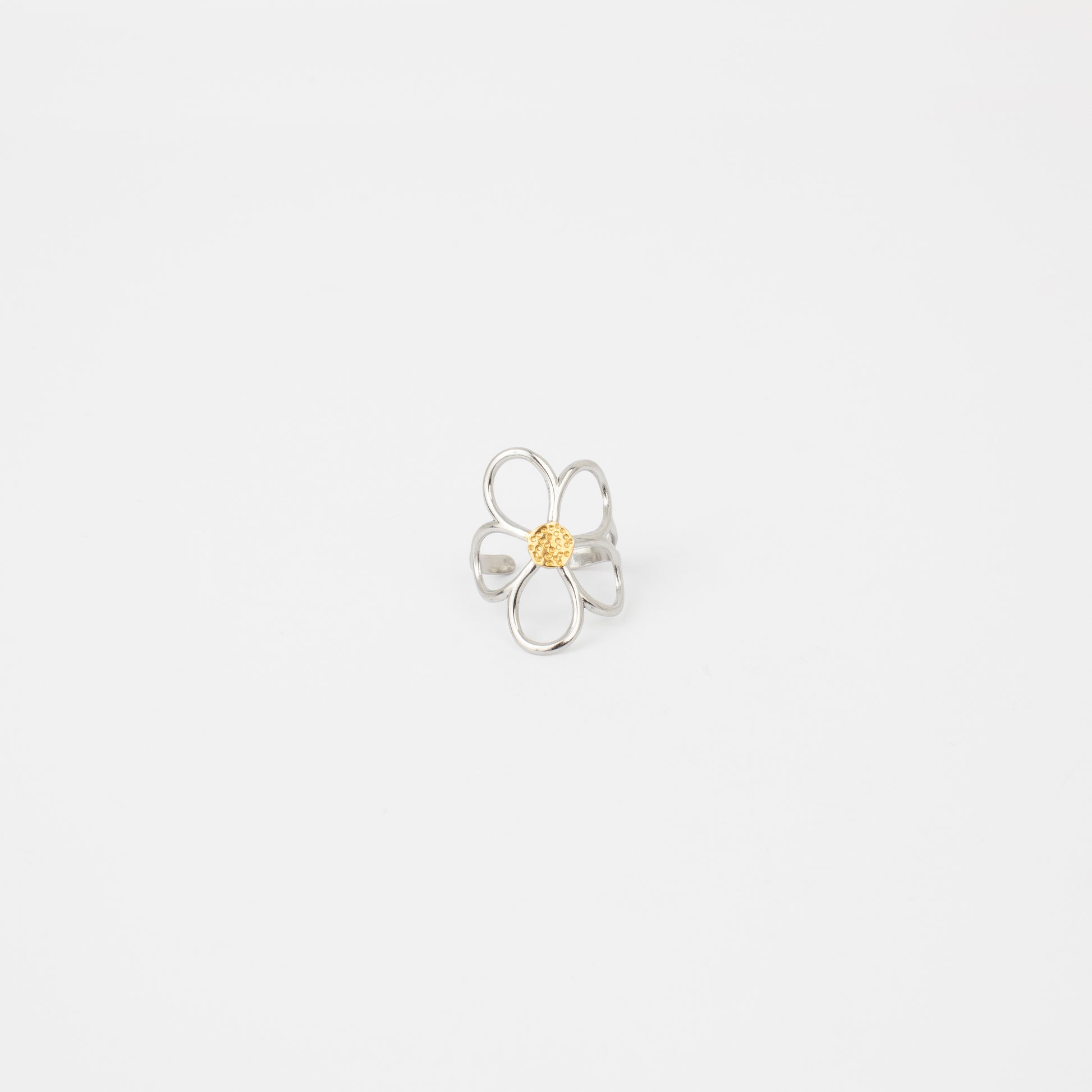 Silver flower-shaped ring with a yellow center on a light gray background