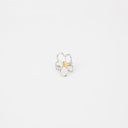 Silver flower-shaped ring with a yellow center on a light gray background