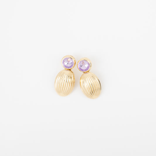 Gold earrings with purple gemstones on a white background