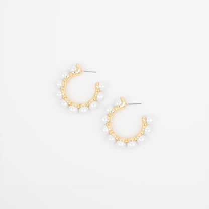 Gold hoop earrings with pearl-like beads on a white background