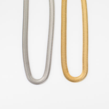 Two necklaces, one silver and one gold, on a white background