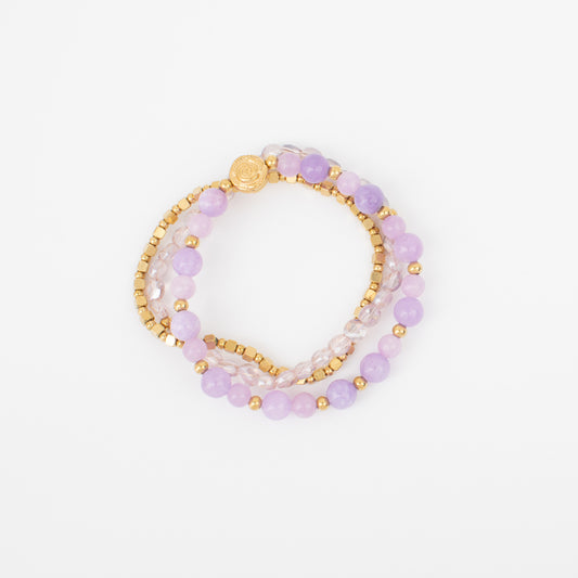 Set of three beaded bracelets with gold accents on a white background